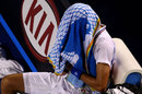 Novak Djokovic hides his head under a towel