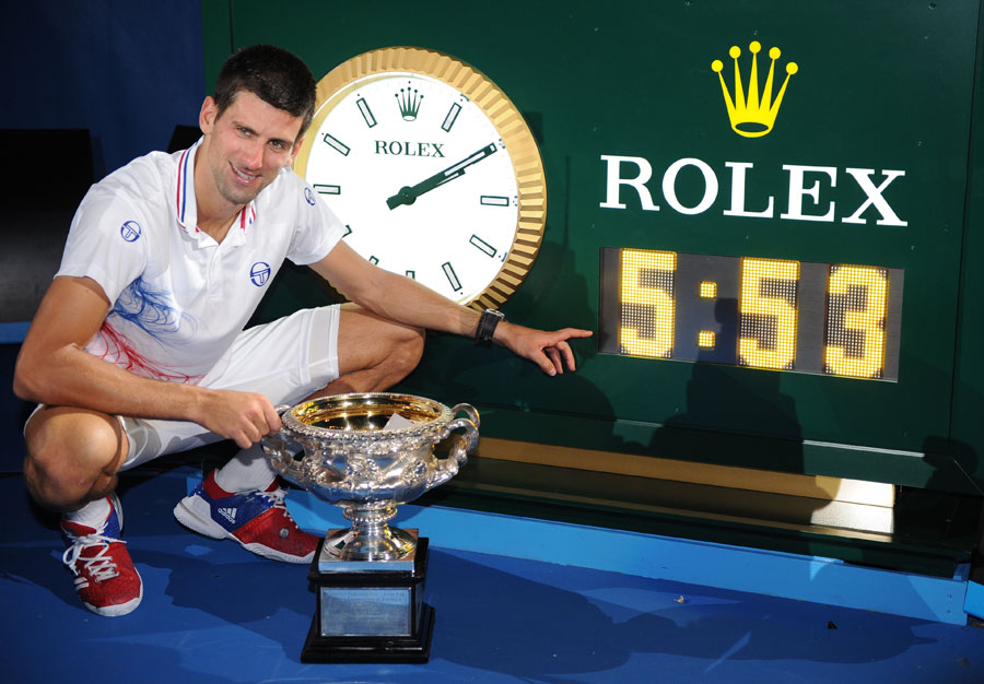 Novak Djokovic shows off his trophy with the clock reading five hours 53 minutes