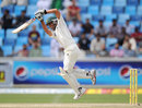 Younis Khan jumps even as he drives down the ground