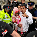 Carlos Tevez is greeted by media and a police escort