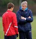 Arsene Wenger talks with Aaron Ramsey before a training session