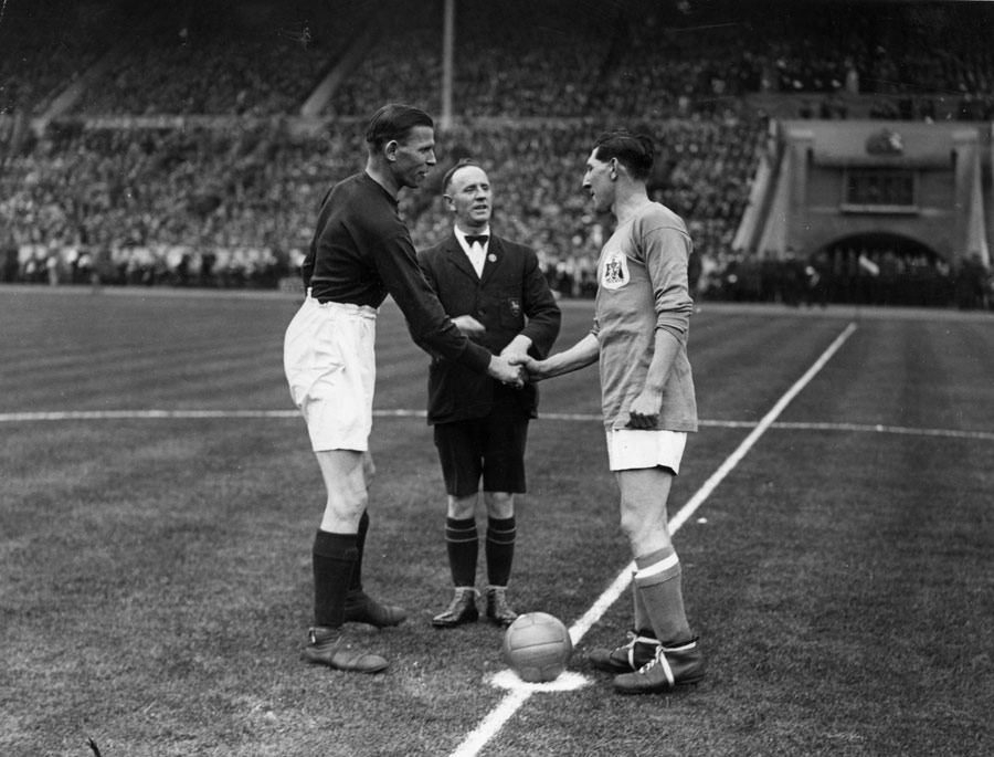 Cardiff captain Fred Keenor shakes the hand of Arsenal's Tom Parker before the game