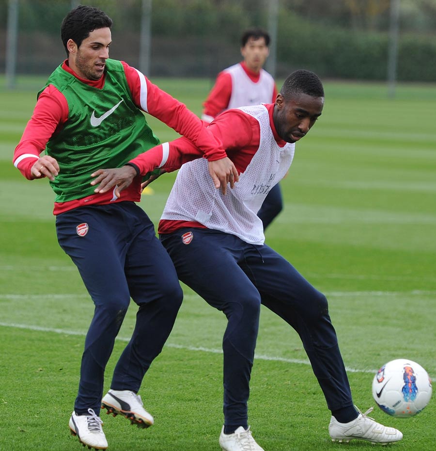 Mikel Arteta and Johan Djourou compete during a training session