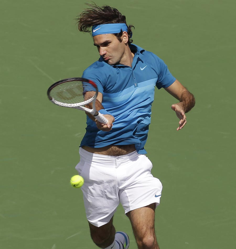 Roger Federer returns a shot to John Isner