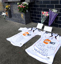 Football shirts and flowers are seen left outside the Reebok Stadium