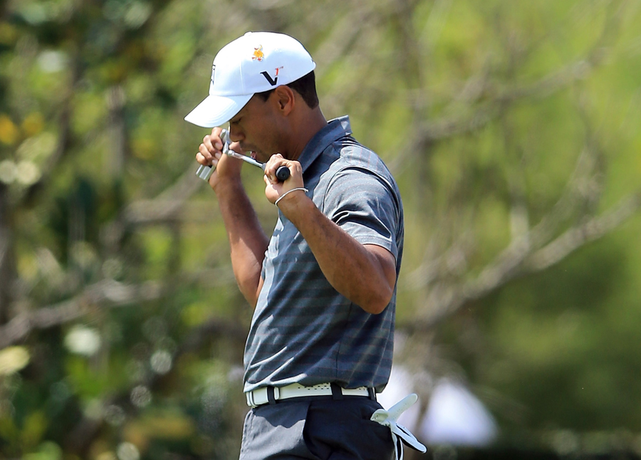 Tiger Woods reacts as a putt slips by