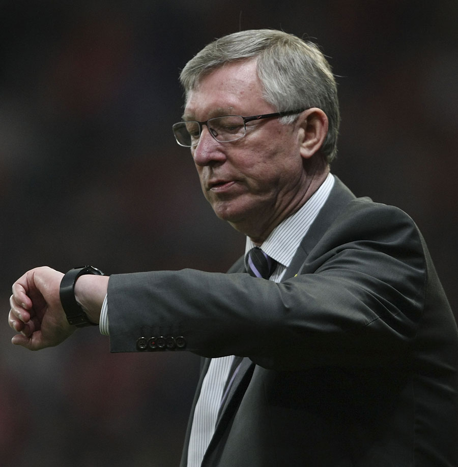 Sir Alex Ferguson checks his watch