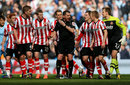 Sunderland's players surround referee Phil Dowd