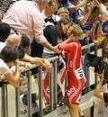 Sir Chris Hoy climbs the barrier and kisses wife Sara after winning the men's keirin 