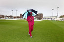 Darren Sammy needs his umbrella as he inspects the pitch