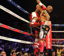 Floyd Mayweather Jr is pushed back on the ropes by Miguel Cotto