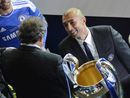 Roberto Di Matteo looks at UEFA president Michel Platini as he holds the trophy 