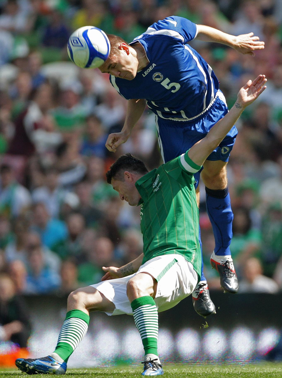 Robbie Keane is beaten in the air by Boris Pandza