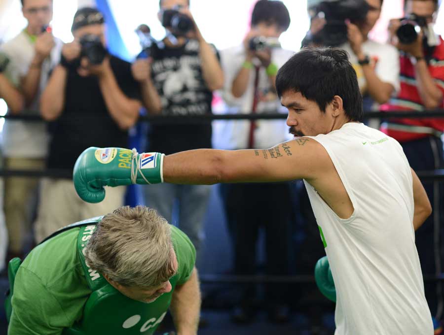 Freddie Roach takes cover as Manny Pacquiao throws a straight left
