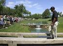 Tiger Woods walks on a bridge to the 15th tee