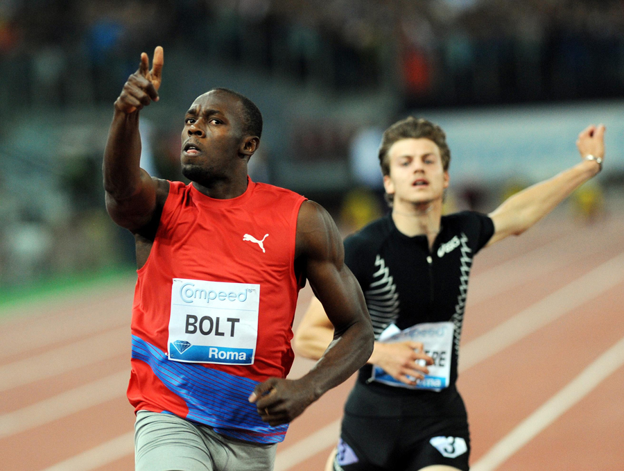 Usain Bolt crosses the line and celebrates as Christoph Lemaitre trails