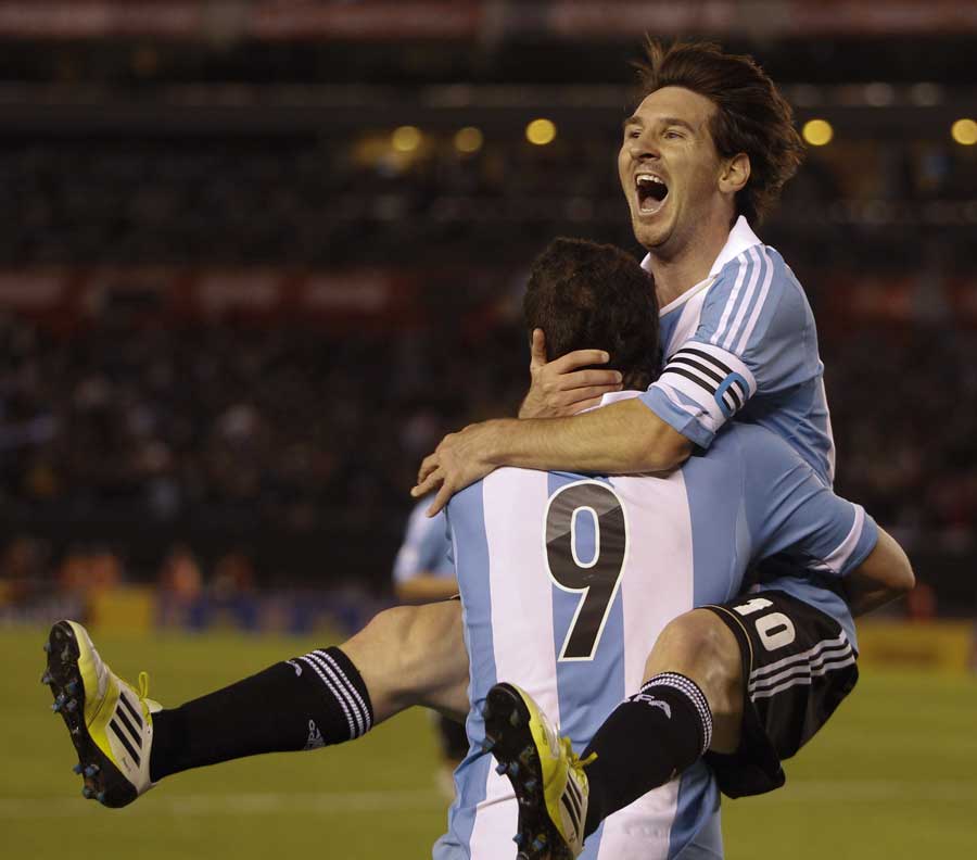 Lionel Messi jumps into a team-mate's arms