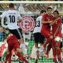 Lukas Podolski fires a free-kick into the wall