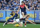 Ben Sinclair of Collingwood smothers a kick from James Frawley of Melbourne