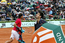 Novak Djokovic looks nervously at the sky as Rafael Nadal heads back to his chair