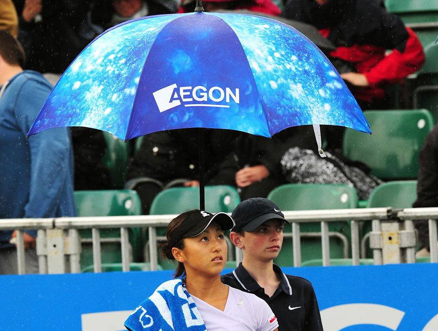 Misaki Doi leaves the court as rain stops play