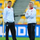 Steven Gerrard and Wayne Rooney walk around the pitch