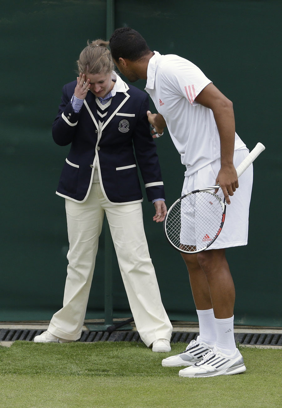 Jo-Wilfried Tsonga checks on a line judge after she got a ball in the face