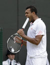Jo-Wilfried Tsonga sticks the handle of his racket in his mouth