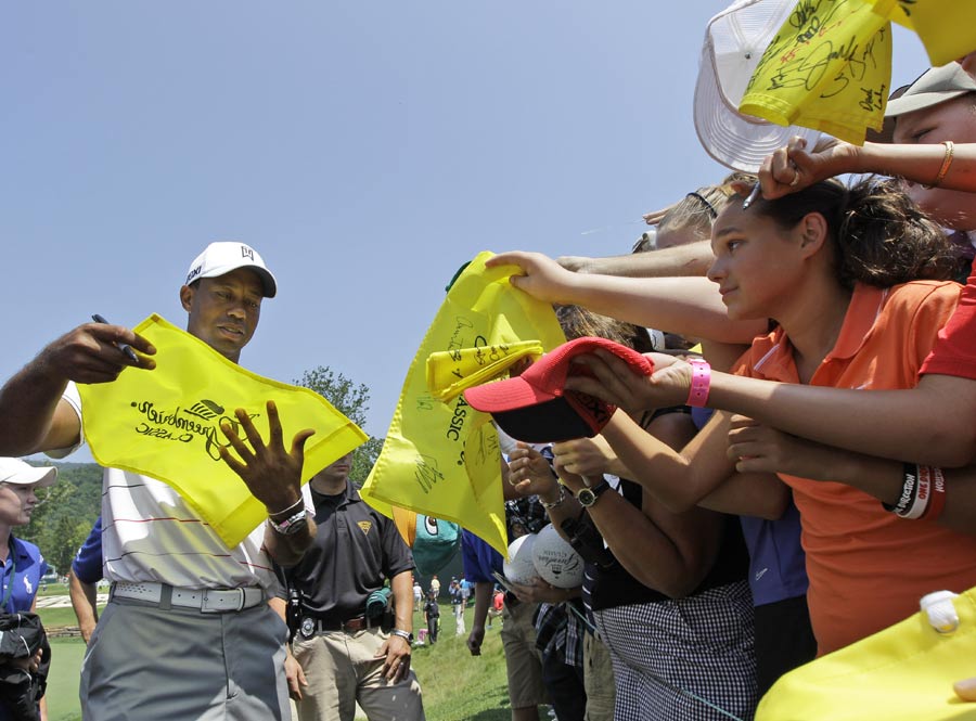 Tiger Woods signs autographs for fans after the ProAm