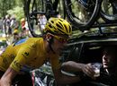 Bradley Wiggins takes a glass of Champagne from a member of his team