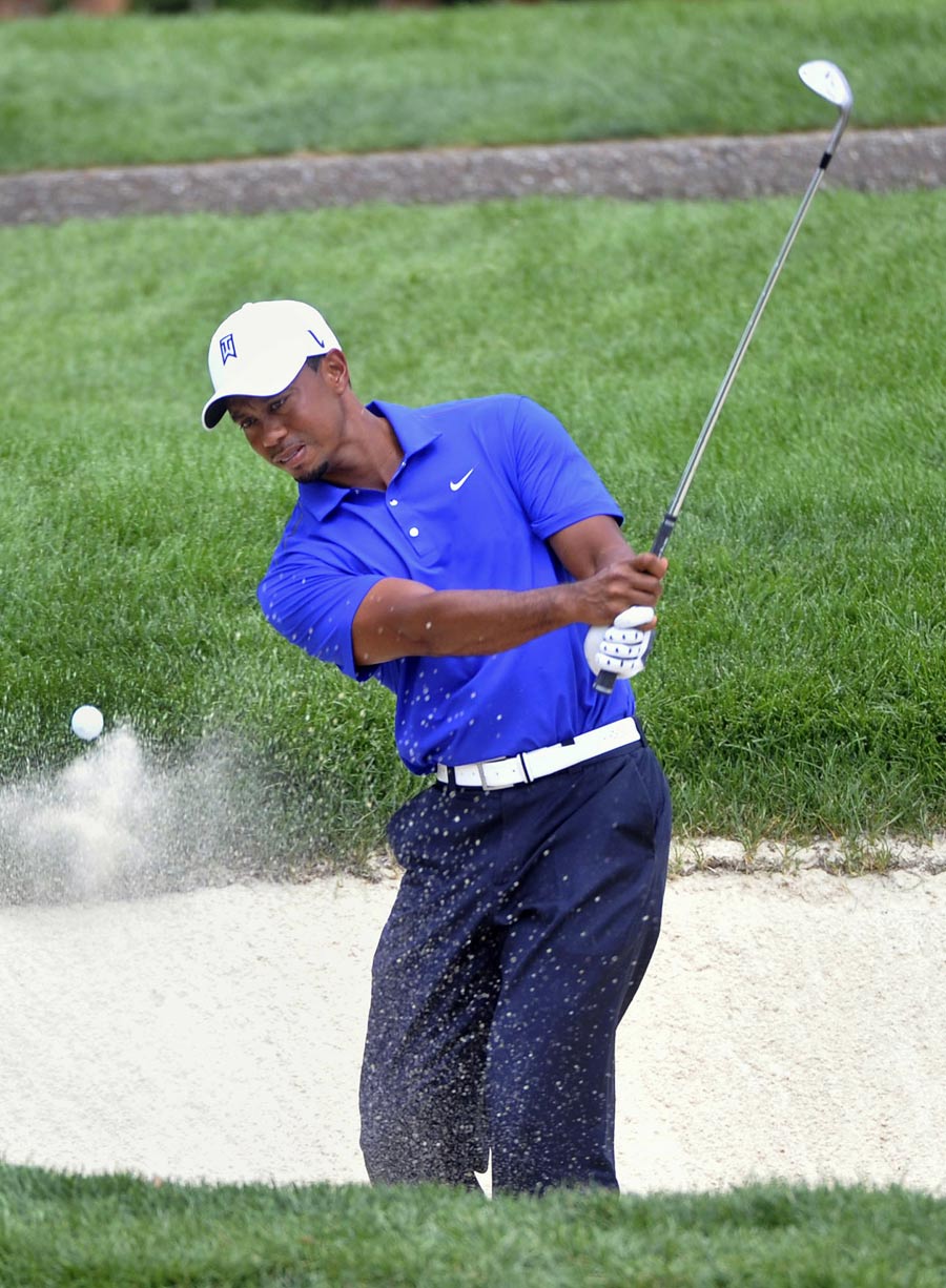Tiger Woods plays from a bunker during practice