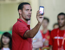 Rio Ferdinand checks his phone
