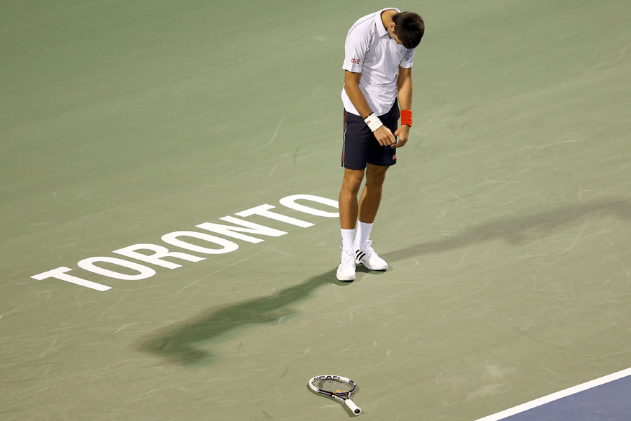 Novak Djokovic hangs his head after a missed return