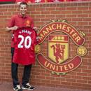 Robin van Persie holds a Manchester United shirt