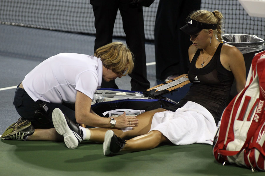 Caroline Wozniacki receives treatment on her leg