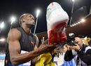 Usain Bolt celebrates with a shoe after winning the men's 200m