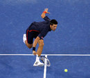 Novak Djokovic stoops to play a volley