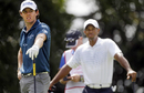 Rory McIlroy watches on as Tiger Woods lingers