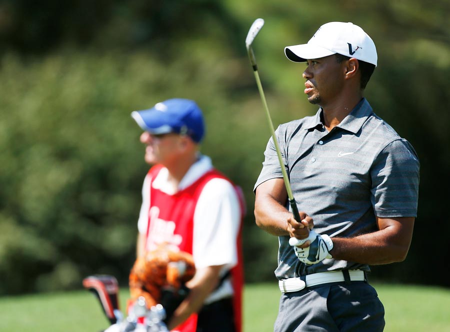 Tiger Woods watches his approach shot on the fourth hole
