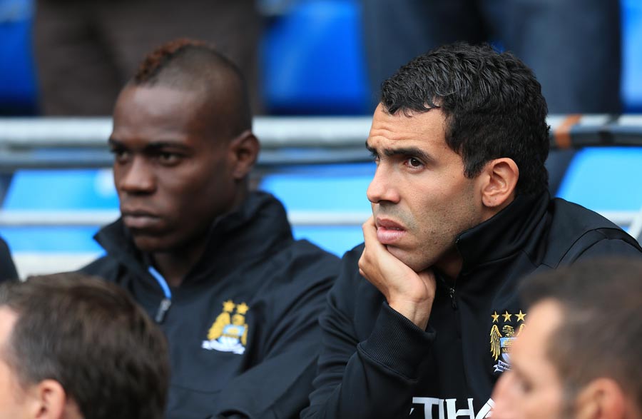 Carlos Tevez and Mario Balotelli sit on the bench