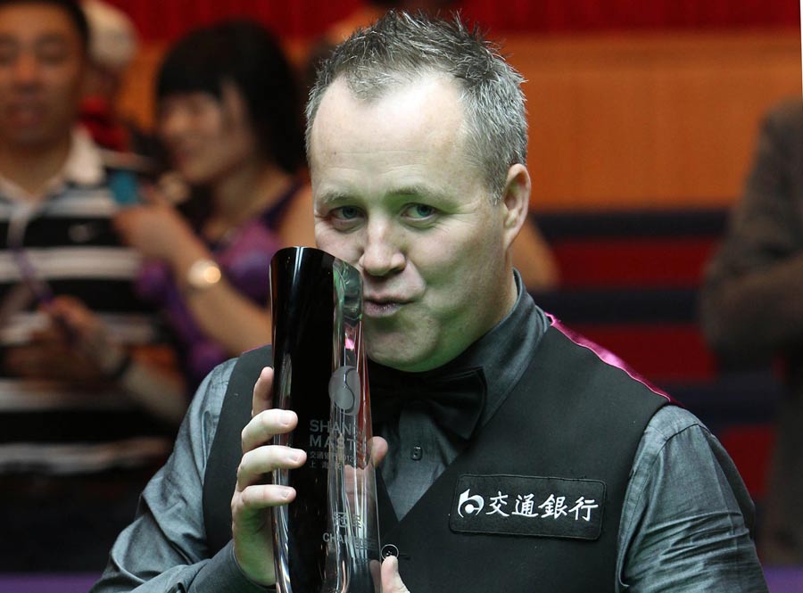 John Higgins poses with the trophy after beating Judd Trump