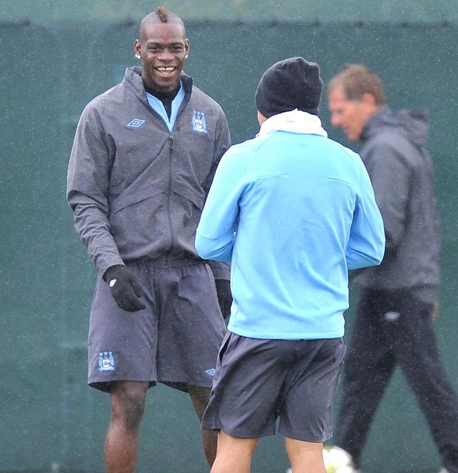 Mario Balotelli laughs during a training session