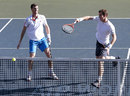 Andy Murray hits a smash as Jamie Murray looks on