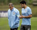 Oscar Tabarez and striker Luis Suarez walk together on the pitch after a training session