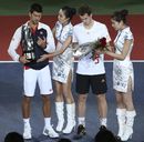 Novak Djokovic and Andy Murray hand their trophies to the hostesses