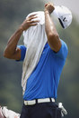 Tiger Woods buries his head in a towel