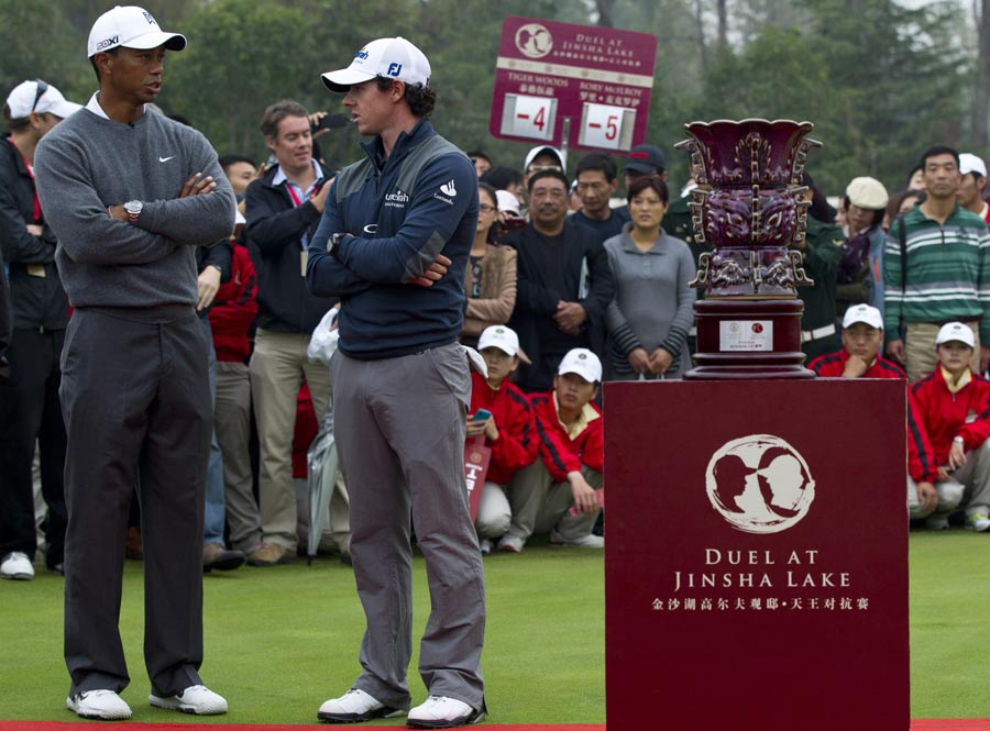 Tiger Woods and Rory McIlroy wait for an award ceremony