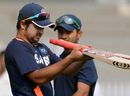 Suresh Raina checks his bat as Ajinkya Rahane looks on during a training session