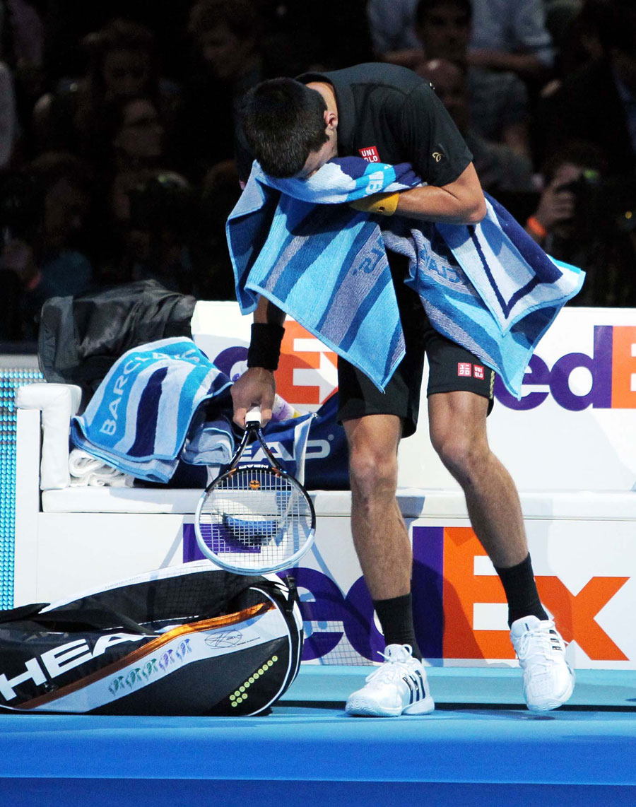 Novak Djokovic hides his head in a towel