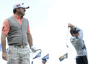 Ian Poulter hits a shot during practice as Graeme McDowell watches on